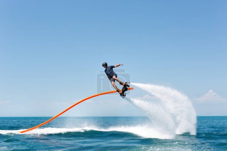 Water extreme sport. The guy is flying at the aquatic flyboard. A lot of water pressure