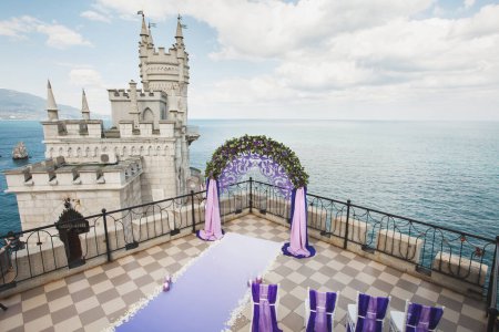 Téléchargez les photos : Arc de mariage de couleur pourpre sur le fond de la mer - en image libre de droit