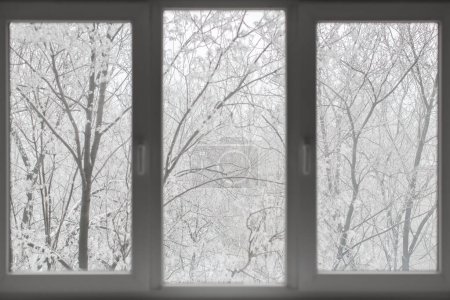 Fenster mit Winterblick auf schneebedeckten Hintergrund