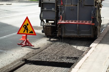 Téléchargez les photos : Réparation d'asphalte. Fraser et panneau routier - en image libre de droit
