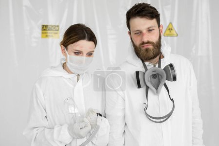 Photo for Exhausted doctors or nurses taking of protective mask uniform. Coronavirus Covid-19 outbrek. Mental state of medical professional. Overworked health workers with tears in his eyes. - Royalty Free Image