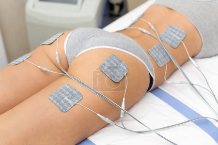 Beautiful woman getting electrostimulation therapy, anti-cellulite and anti-fat therapy on her tight buttocks in beauty salon