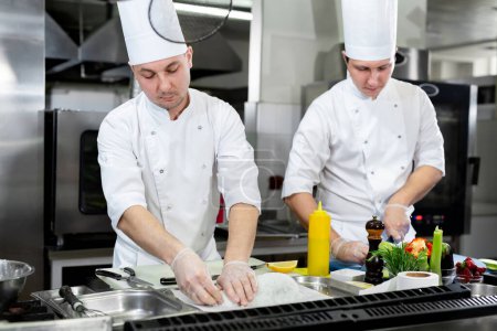 Photo for Chefs prepare meals in the kitchen - Royalty Free Image