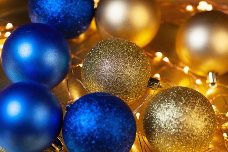 Foto de Tarjeta de Navidad con bolas brillantes doradas y azules, plato de madera con letras de Feliz Navidad y luces de Navidad - Imagen libre de derechos