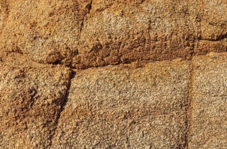 Rock surface with cracks. Natural rock structure. Brown texture. Stone background. Rock texture. Surface of Wild Stone