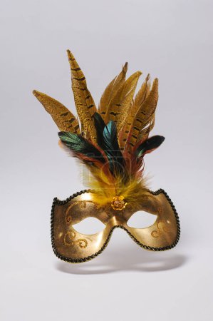 Foto de Máscara de carnaval dorado con plumas sobre fondo blanco. Aislado - Imagen libre de derechos