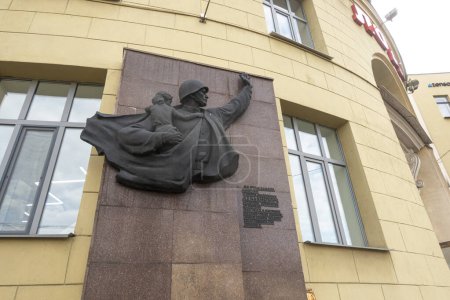 Foto de Minsk, Bielorrusia. 15 de octubre de 2023 Bajorrelieve en la fachada de un edificio en Minsk en honor a la hazaña del guerrero Trifon Lukyanovich que salvó a una niña alemana en 1945 - Imagen libre de derechos