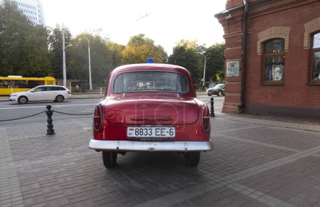 Photo for Minsk, Belarus. October 15, 2023 Retro car Moskvich 407 near the historical fire department building, rear view - Royalty Free Image