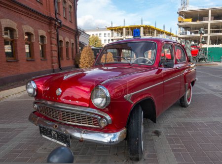 Photo for Minsk, Belarus. October 15, 2023 Retro car Moskvich 407 near the historical fire department building, front view - Royalty Free Image