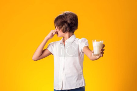 Foto de A la chica con un vaso de leche no le gusta. Lácteos Persona intolerante. Intolerancia a la lactosa, concepto de atención sanitaria. - Imagen libre de derechos