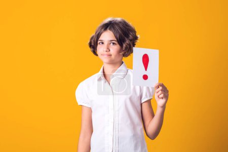 Photo for A portrain of kid girl holding exclamation point card. Children, idea and knowledge concept - Royalty Free Image