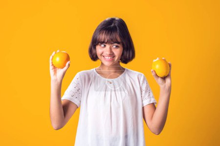 Foto de La chica tiene una naranja en las manos. Comida saludable, vitaminas y concepto de nutrición para niños - Imagen libre de derechos