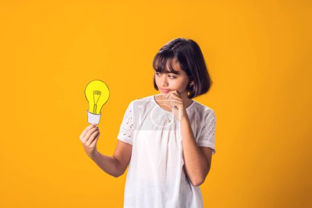 Photo for Child girl holding paper bulb. Success, motivation, winner, genius, idea concept - Royalty Free Image
