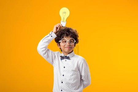 Photo for Child boy holding paper bulb. Success, motivation, winner, genius, idea concept - Royalty Free Image