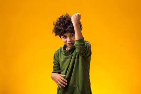 Photo for Portrait of angry child boy on yellow background. Negative children's emotions concept - Royalty Free Image
