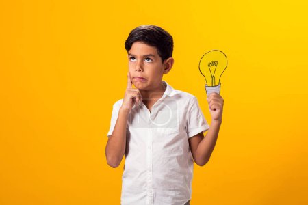 Téléchargez les photos : Un enfant tenant une ampoule en papier. Succès, motivation, vainqueur, génie, concept d'idée - en image libre de droit