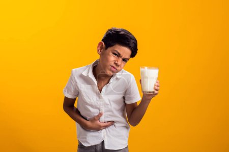 Photo for Boy with glass of milk feeling stomach pain. Dairy Intolerant person. Lactose intolerance, health care concept. - Royalty Free Image