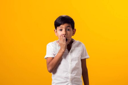 Photo for Portrait of surprised kid boy over yellow background. Astonished shocked facial expression, opening mouth widely and holding hands on his cheeks - Royalty Free Image