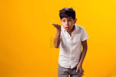 Téléchargez les photos : Portrait de garçon enfant surpris sur fond jaune. Étonné expression faciale choquée, ouvrant largement la bouche et tenant les mains sur ses joues - en image libre de droit