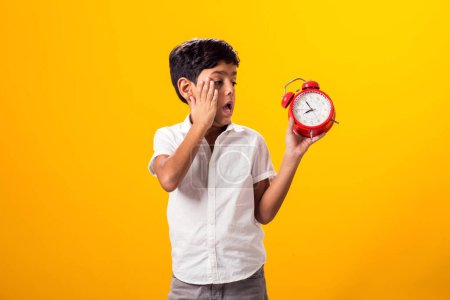 Photo for Portrait of surprised kid boy holding alarm clock. Education and time management concept - Royalty Free Image