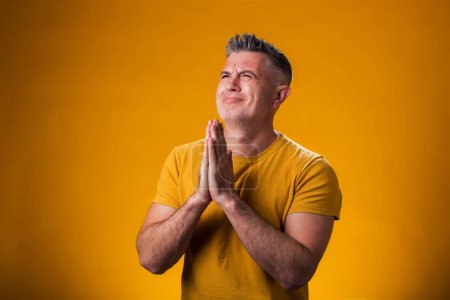 Photo for Portrait of man showing praying or hope gesture. People and emotion concept - Royalty Free Image