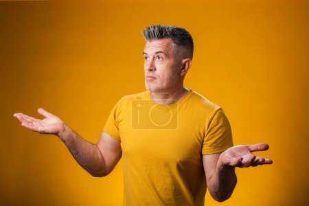 Photo for Portrait of confused man looking puzzled, have no idea, nothing to say, standing questioned and unaware. People and emotions concept - Royalty Free Image