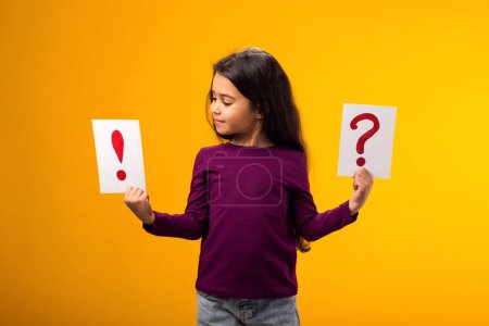 Photo for A portrait of smiling kid girl holding cards with question mark and exclamation point. Children, idea and knowledge concept - Royalty Free Image