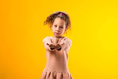 Foto de Retrato de niña sosteniendo algo con las palmas abiertas, ofreciéndole a la cámara. Mostrando palmas en la cámara - Imagen libre de derechos