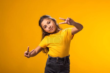 Photo for Portrait of smiling kid girl looking at camera over yellow background. Childhood and  positive emotions concept - Royalty Free Image