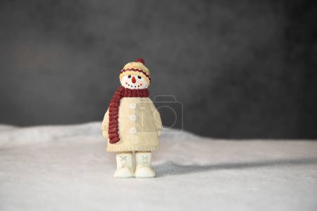 Foto de Figura de persona de nieve completamente vestida aislada sobre nieve blanca con fondo gris - Imagen libre de derechos