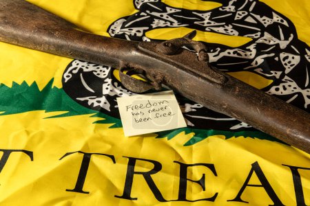 Photo for Old musket rifle on yellow don't tread on me Gadsden flag with freedom has never been free note - Royalty Free Image