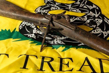 Photo for Old musket gun with metal cross on yellow don't tread on me Gadsden flag - Royalty Free Image