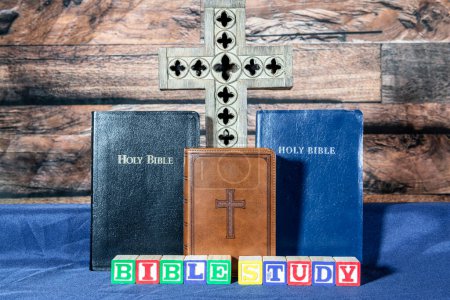 Foto de Tres biblias y cruz de madera en azul con bloques de madera deletreo estudio de la biblia - Imagen libre de derechos