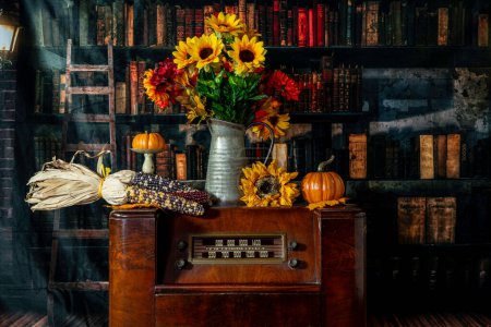 Photo for Vintage radio decorated for autumn with pumpkins sunflowers and corn with old library background - Royalty Free Image
