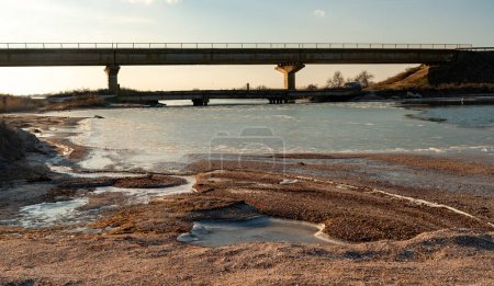 Photo for View of the old and new bridge over the canal on the banks of the Tiligul estuary, frozen water, Ukraine - Royalty Free Image