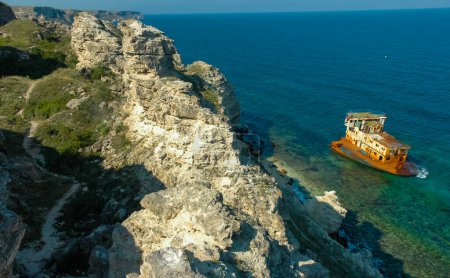 Photo for The remains of a sunken ship near the coastal cliffs in the tract Dzhangul, western Crimea - Royalty Free Image