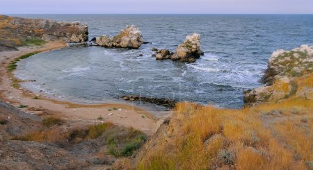 Foto de Una pequeña cala de arena acogedora entre las rocas costeras en la Crimea oriental, Kazantip, el Mar Negro - Imagen libre de derechos