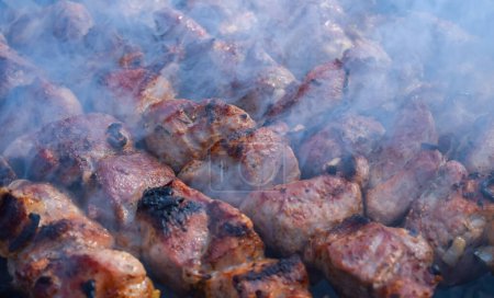 Photo for Pork meat is fried on smoking coals in the grill - Royalty Free Image