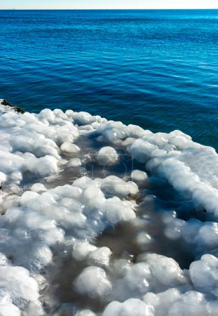 Glaçage d'une jetée en béton dans la mer Noire, blocs de glace fondue brillent au soleil, glace au bord de la mer, Odessa