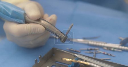 Photo for Doctor's hands with a working tool. Preparation and process of dental treatment. Dental instrument in the office of a modern dentist. Close-up in 4K, UHD - Royalty Free Image