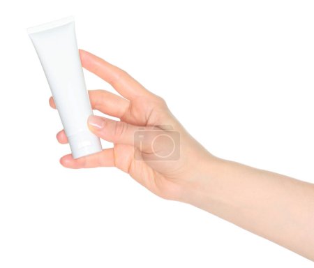 Femme main tient un tube de crème cosmétique blanc, sur un fond blanc gros plan, modèle pour les annonces cosmétiques