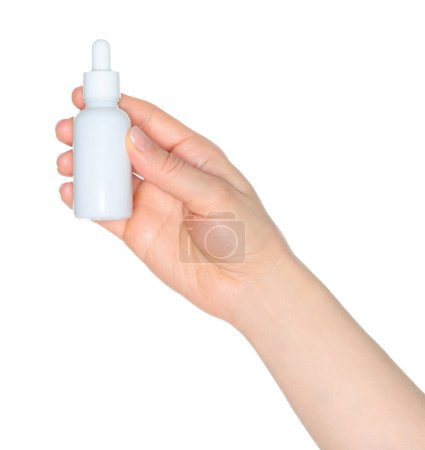 Femme main tient un flacon cosmétique blanc, isolé sur un fond blanc gros plan, modèle pour les annonces cosmétiques