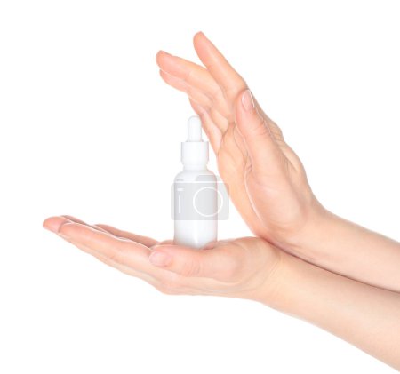 Femme mains tenant une bouteille cosmétique blanche, isolé sur un fond blanc gros plan, modèle pour les annonces cosmétiques