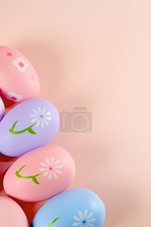 Foto de Huevos de Pascua coloridos con flores pintadas sobre fondo rosa - Imagen libre de derechos