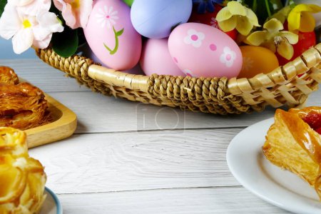 Foto de Huevos de Pascua en cesta y pasteles sobre fondo blanco. concepto de Pascua - Imagen libre de derechos