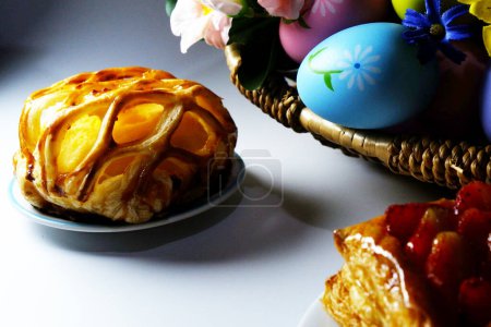Foto de Huevos de Pascua en cesta y pasteles sobre fondo blanco. concepto de Pascua - Imagen libre de derechos