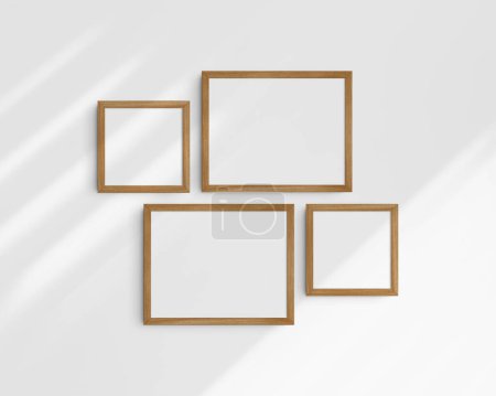 Photo for Gallery wall mockup set, 4 cherry wood frames. Clean, modern, and minimalist frame mockup. Two horizontal frames and two square frames, 14x11 (14:11), 8x8 (1:1) inches, on a white wall with shadows. - Royalty Free Image