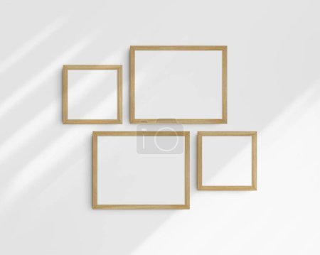 Foto de Conjunto de maquetas de pared Gallery, 4 marcos de madera de roble. Maqueta de marco limpia, moderna y minimalista. Dos marcos horizontales y dos cuadrados, 14x11 (14: 11), 8x8 (1: 1) pulgadas, en una pared blanca con sombras. - Imagen libre de derechos