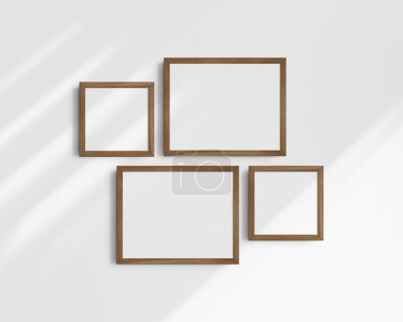 Téléchargez les photos : Coffret maquette murale Galerie, 4 cadres en bois de noyer marron. Modèle de cadre propre, moderne et minimaliste. Deux cadres horizontaux et deux cadres carrés, 14x11 (14 : 11), 8x8 (1 : 1) pouces, sur un mur blanc avec des ombres. - en image libre de droit