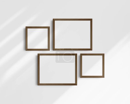 Foto de Conjunto de maquetas de pared Gallery, 4 marcos de madera de nogal marrón oscuro. Maqueta de marco limpia, moderna y minimalista. Dos marcos horizontales y dos cuadrados, 14x11 (14: 11), 8x8 (1: 1) pulgadas, en una pared blanca con sombras. - Imagen libre de derechos
